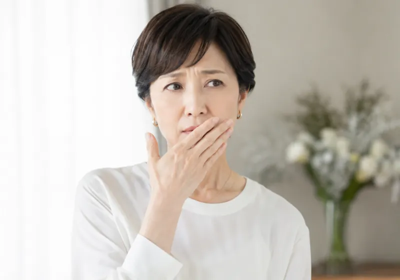 口元を押さえる女性
