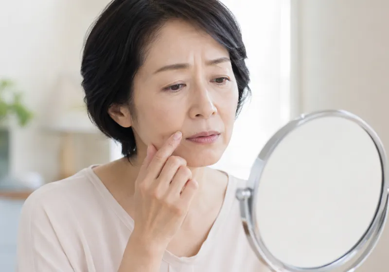 鏡で口元を確認する女性