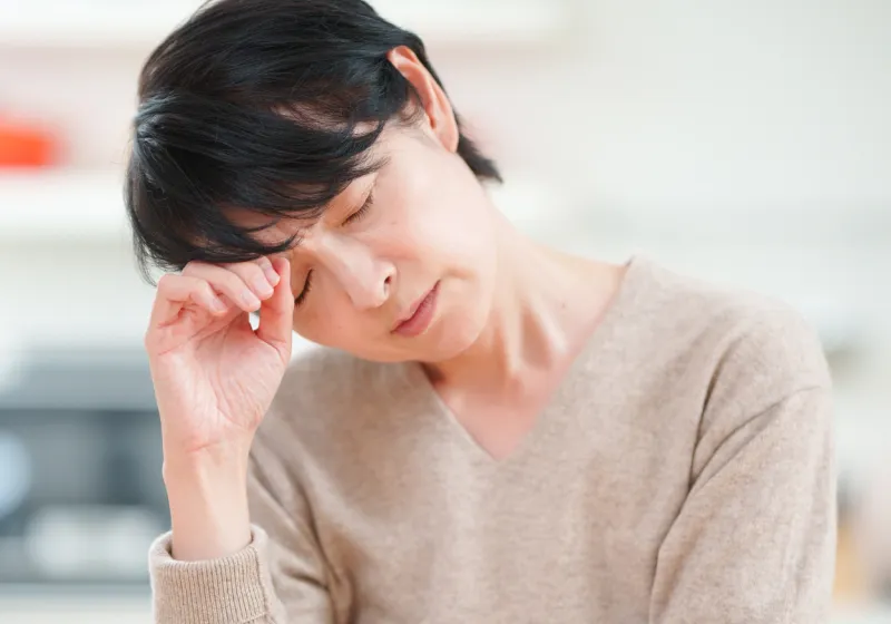 頭を押さえる女性
